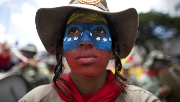 Una mujer con el rostro pintado con los colores de la bandera de Venezuela - Sputnik Mundo
