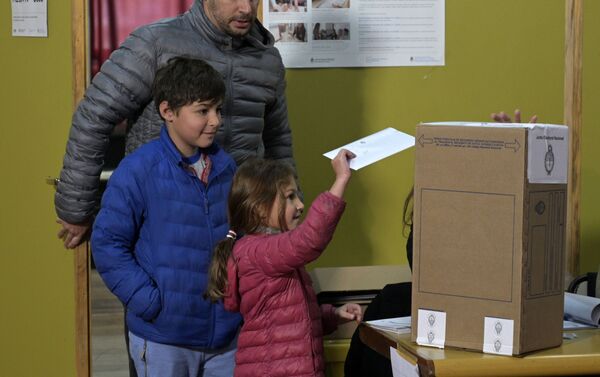 Una niña depositando el voto de su padre - Sputnik Mundo