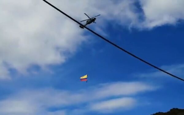 Dos soldados con la bandera de Colombia, colgados de un helicóptero, durante un espectáculo aéreo - Sputnik Mundo