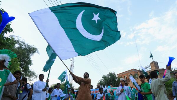 Un hombre con la bandera de Pakistán - Sputnik Mundo