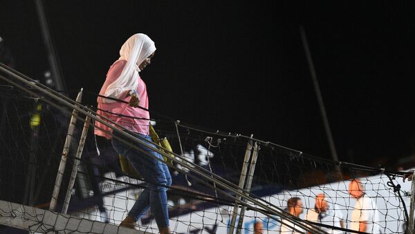 Una mujer bajando del Open Arms en Lampedusa - Sputnik Mundo