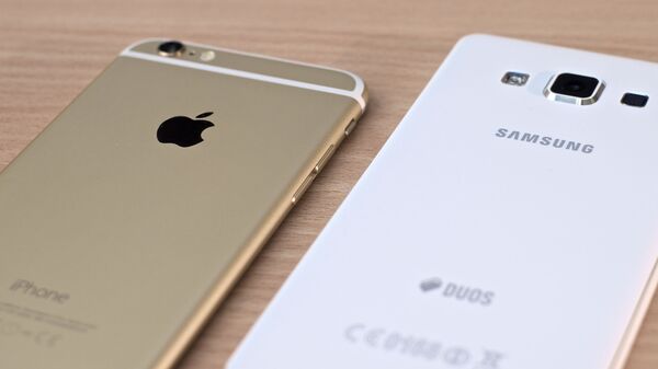 Un iPhone de Apple y un teléfono de Samsung - Sputnik Mundo