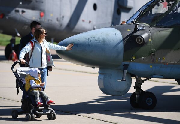 Пара с ребенком у военного вертолета Ка-52 Аллигатор на Международном авиационно-космическом салоне МАКС-2019 в подмосковном Жуковском - Sputnik Mundo