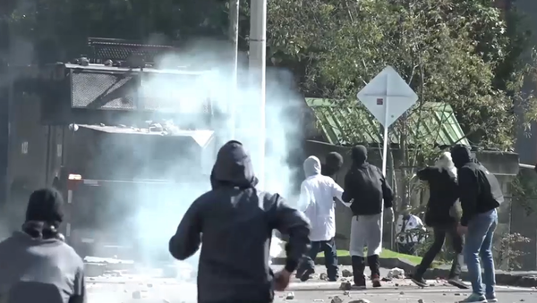 Piedras contra gases lacrimógenos: los estudiantes se enfrentan a la Policía en Bogotá - Sputnik Mundo