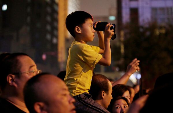 Мальчик наблюдает в бинокль за репетицией парада в честь 70-летия образования КНР - Sputnik Mundo