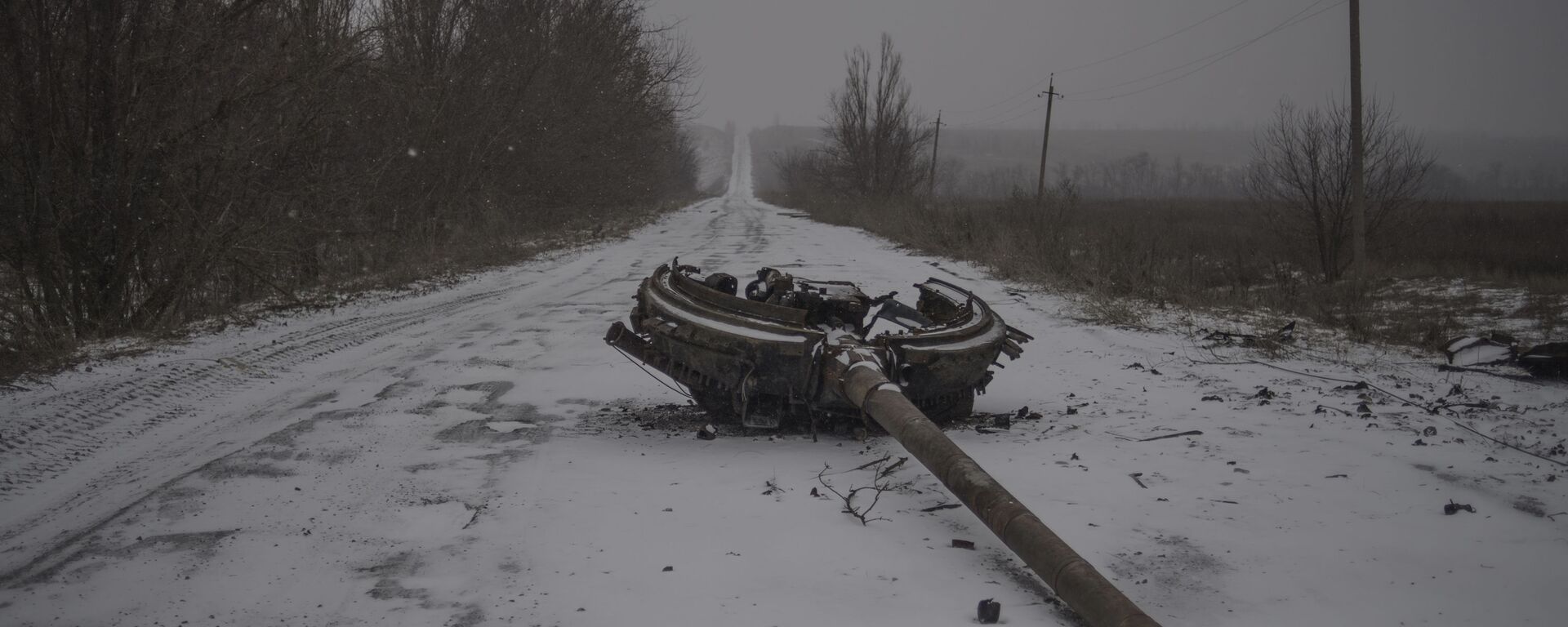 Un fragmento de una torre de tanques en la carretera, consecuencia del bombardeo del pueblo de Kominternovo, región de Donetsk (foto de la serie Zona Gris) - Sputnik Mundo, 1920, 31.01.2022