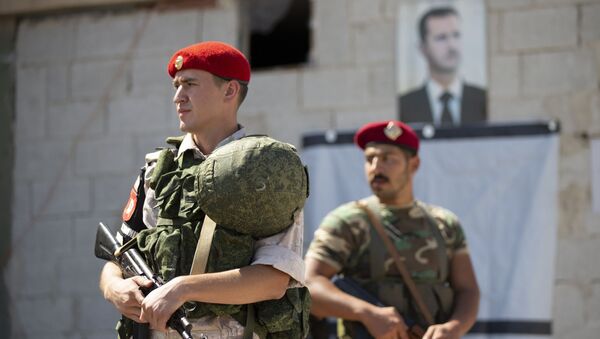 Un soldado ruso y otro sirio ante el retrato del presidente Bashar Asad (archivo) - Sputnik Mundo