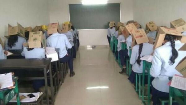 Una escuela hace a sus alumnos usar cajas en la cabeza en los exámenes - Sputnik Mundo