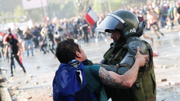 Manifestante se enfrenta a las fuerzas de seguridad de Santiago (Chile), el 24 de octubre de 2019 - Sputnik Mundo