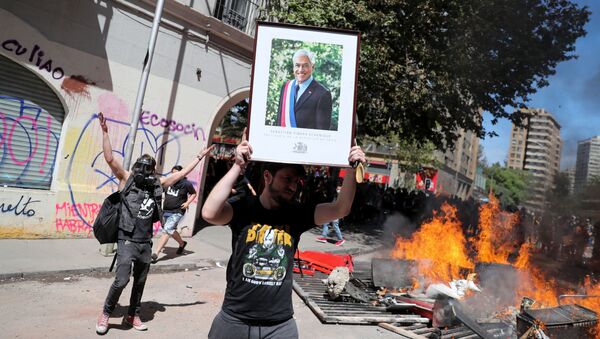 Un manifestante con la imagen del presidente chileno Sebastián Piñera - Sputnik Mundo