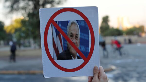 Un manifestante con la imagen del presidente chileno Sebastián Piñera - Sputnik Mundo