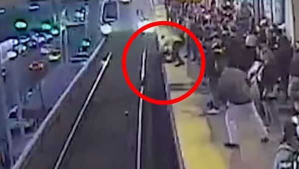 El aterrador momento en el que un hombre se cae a la vía del metro justo delante de un tren - Sputnik Mundo