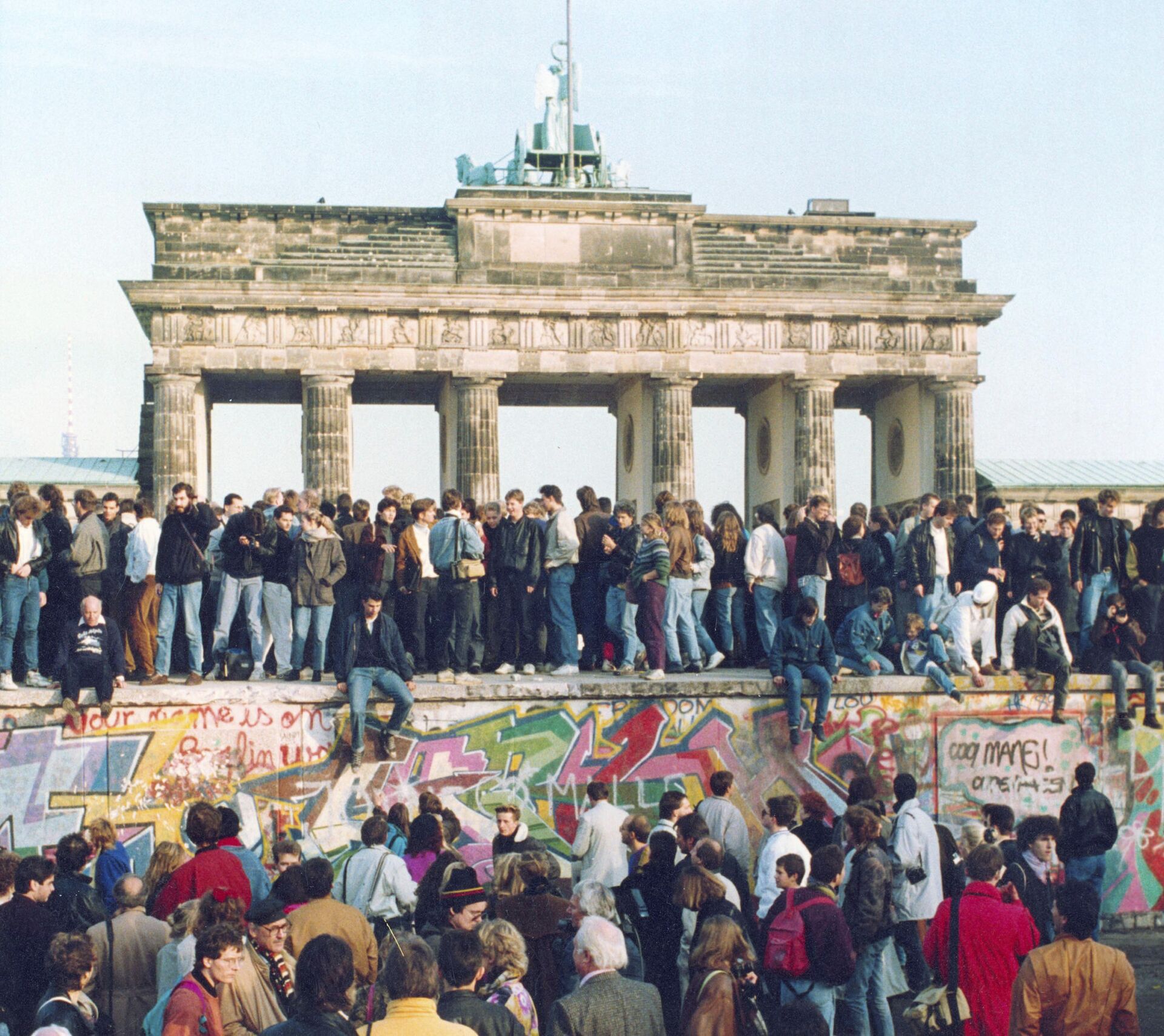 Alemanes de ambos lados se paran en el Muro de Berlín frente a la Puerta de Brandenburgo  - Sputnik Mundo, 1920, 02.03.2022