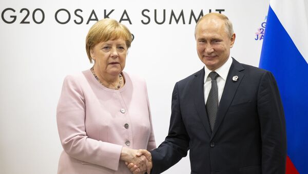 El presidente ruso, Vladímir Putin y la canciller alemana, Angela Merkel, durante la cumbre del G-20 en Osaka - Sputnik Mundo