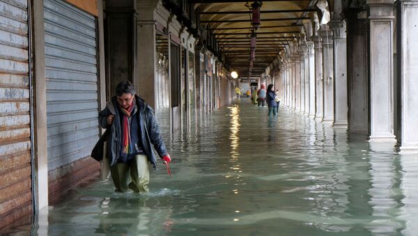 Человек на площади Сан-Марко в Венеции во время наводнения - Sputnik Mundo
