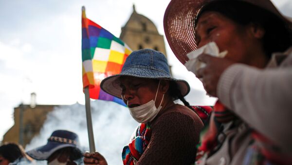 Manifestantes con banderas de Wiphala cubren sus bocas durante los enfrentamientos entre partidarios del expresidente boliviano, Evo Morales, y las fuerzas de seguridad en La Paz (Bolivia). - Sputnik Mundo