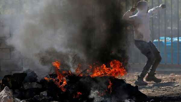 Un manifestante lanza la piedra durante protestas contra la demolición de los edificios palestinos - Sputnik Mundo