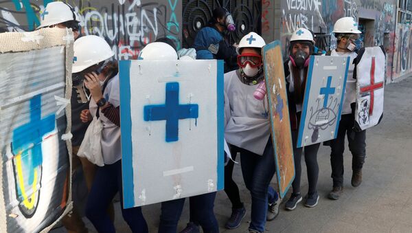 Paramédicos se protegen durante las manifestaciones de protesta en Chile - Sputnik Mundo