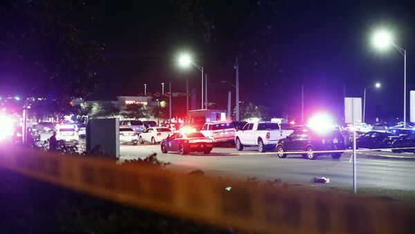 Una fila de vehículos y un camión de UPS se ven detrás de la cinta policial tras un tiroteo en Miramar, Florida - Sputnik Mundo