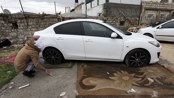 Un palestino examina su coche con los neumáticos rajados en Jerusalén Este - Sputnik Mundo