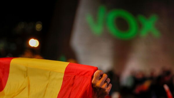 La bandera de España con el letrero de Vox al fondo - Sputnik Mundo
