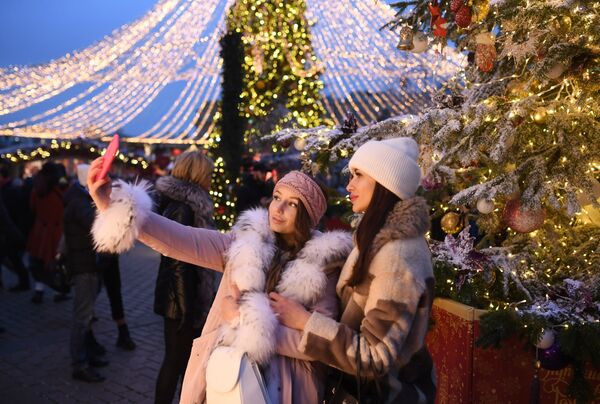 Девушки фотографируются на фестивале Путешествие в Рождество на Манежной площади в Москве - Sputnik Mundo