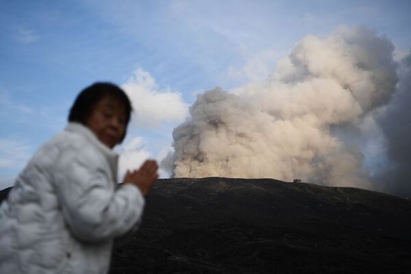 Женщина на фоне действующего вулкана в городе Асо в префектуре Кумамото - Sputnik Mundo
