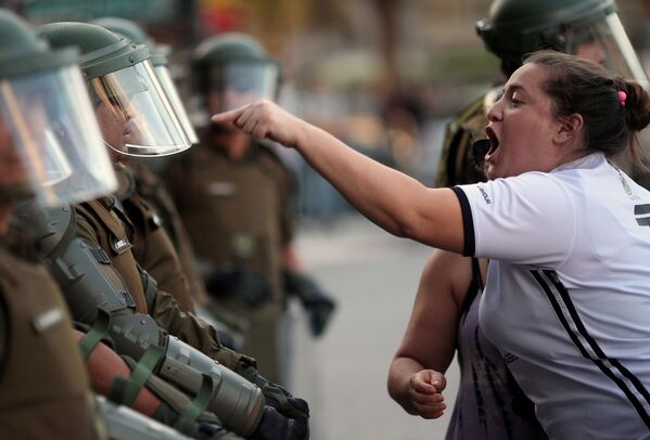 Женщина кричит на чилийских полицейских - Sputnik Mundo