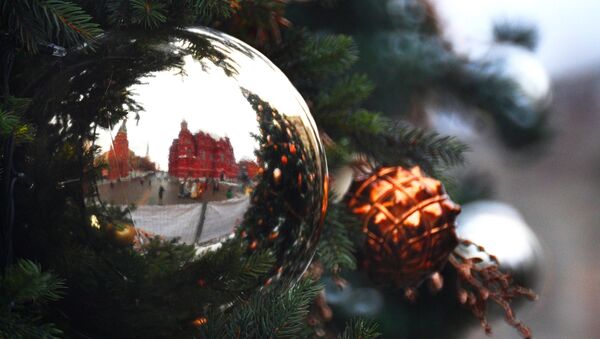 Los muros de la Plaza Roja de Moscú reflejados en un adorno navideño - Sputnik Mundo