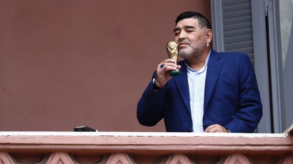 El exfutbolista Diego Armando Maradona besa una réplica de la Copa del Mundo en el balcón de la Casa Rosada - Sputnik Mundo