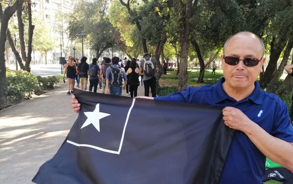 Algunos de los que asistieron a la manifestación portaron banderas de Chile en color negro para conmemorar a los fallecidos durante la crisis social que está viviendo el país.  - Sputnik Mundo