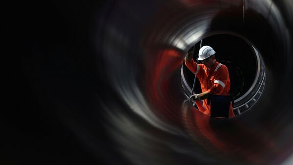 Un trabajador es visto a través de una tubería en el sitio de construcción del gasoducto Nord Stream 2 en Rusia - Sputnik Mundo