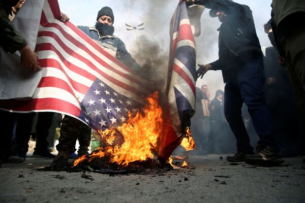 Iraníes queman banderas de EEUU y el Reino Unido tras la muerte del general Soleimani - Sputnik Mundo