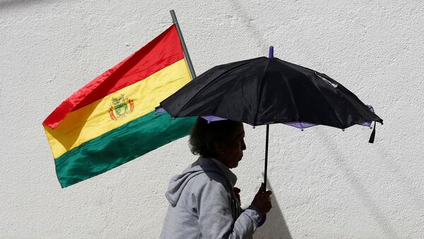 Una mujer con un paraguas y una bandera de Bolivia - Sputnik Mundo