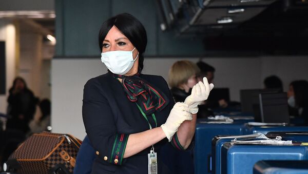  Сотрудница в защитных перчатках и маске при подготовке к регистрации пассажиров у стойки авиакомпании China Southern Airlines в римском аэропорту Фьюмичино  - Sputnik Mundo