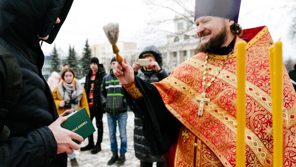 Un sacerdote bendice el boletín de notas de un universitario durante las festividades del Día de Tatiana - Sputnik Mundo