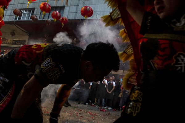 Un bailarín se prepara para intercambiar con una bailarina en la danza del león, durante los festejos del Año Nuevo chino 4718 en la Ciudad de México. - Sputnik Mundo