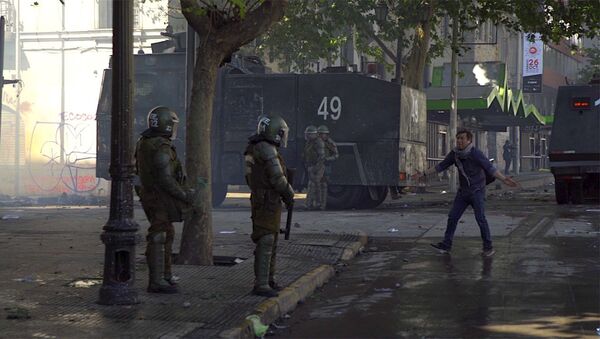 Manifestante frente a policía armada en Chile - Sputnik Mundo