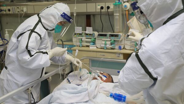 El personal médico trata a un paciente en Wuhan, China - Sputnik Mundo