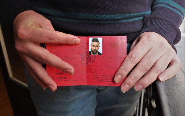 Mohammed Subat, refugiado sirio, muestra su documento de asilo en España. - Sputnik Mundo