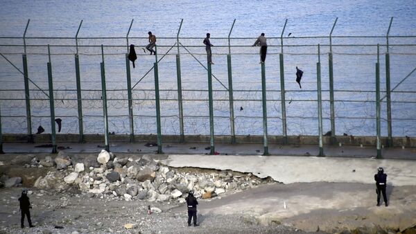 Migrantes en la valla fronteriza que separa la ciudad autónoma española de Ceuta de Marruecos - Sputnik Mundo