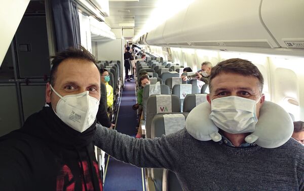 Oliver Cuadrado y Pedro Morilla en el avión con otros repatriados de Wuhan - Sputnik Mundo