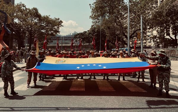Milicianos y milicianas sosteniendo la bandera de Venezuela en la marcha por el Dia de la Mujer en Caracas. - Sputnik Mundo