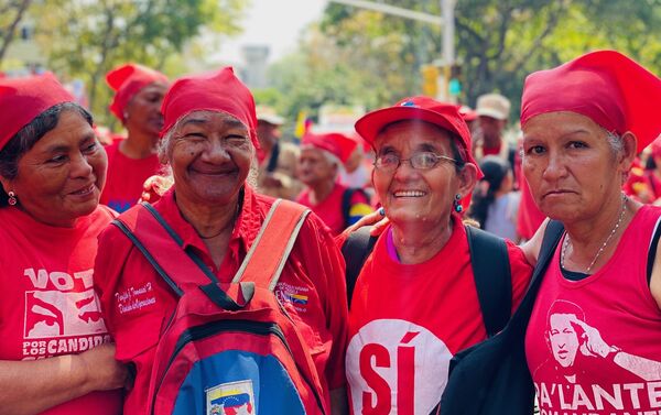 Varias mujeres participando de la marcha por el Dia de la Mujer en Caracas en la avenida Universidad, una arteria central de la capital venezolana por donde ha transcurrido la movilizacion. Las mujeres visten de rojo porque es el color simbolo de la Revolucion bolivariana. La manifestacion ha sido convocada en Venezuela por el Ministerio de la Mujer. - Sputnik Mundo