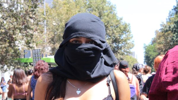 Una joven con capucha en la marcha del 8M en Santiago de Chile - Sputnik Mundo