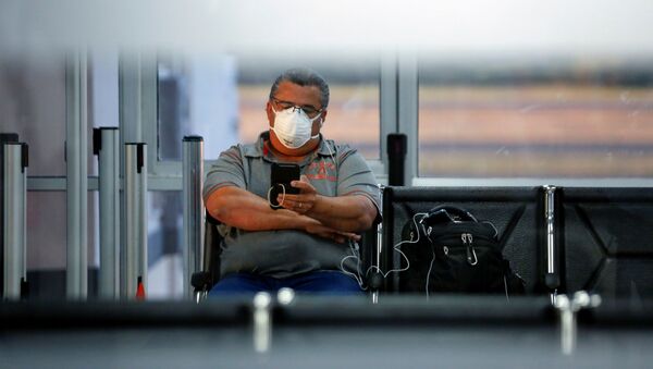 Un hombre con una mascarilla debido al coronavirus en el aeropuerto en El Salvador - Sputnik Mundo