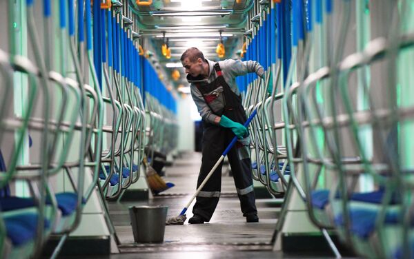 Un empleado frega el suelo en un tren del metro de Moscú - Sputnik Mundo