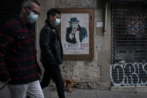Los habitantes de Barcelona cerca de un cartel realizado por un artista callejero donde dice quiero que te quedes en casa. - Sputnik Mundo