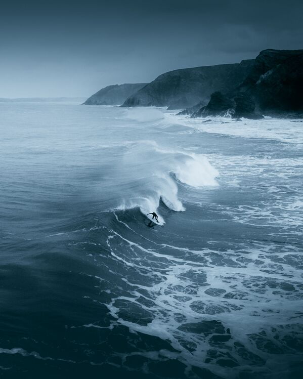 La foto 'Un solitario surfista desafiando el frío del invierno' en la costa norte de Cornualles, de un fotógrafo británico, presentada para el concurso The World's Best Photos of #Water2020. - Sputnik Mundo