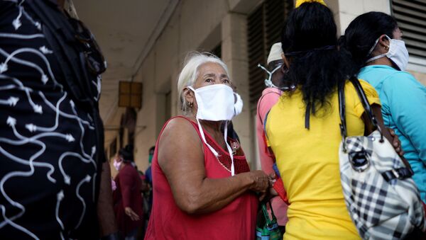 Cubanos utilizan mascarillas para protegerse del coronavirus, mientras esperan en una fila para comprar alimentos en La Habana - Sputnik Mundo